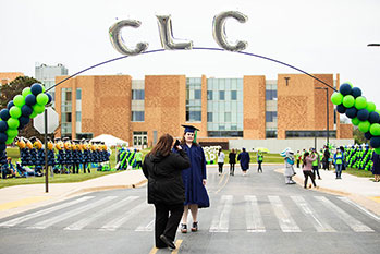 在格雷斯莱克的T大楼前，一位CLC毕业生正在拍照